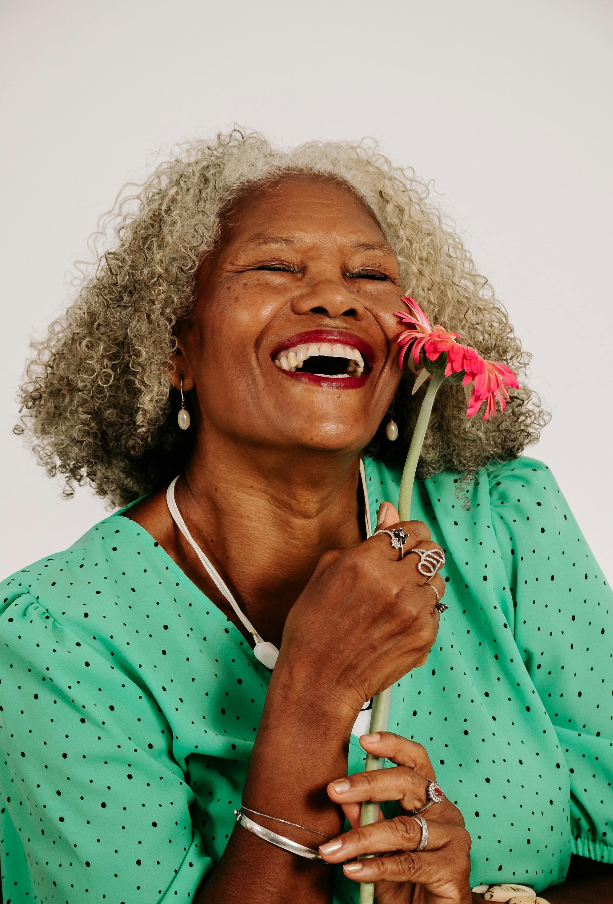 Une dame souriante qui tient une fleur Une dame souriante qui tient une fleur